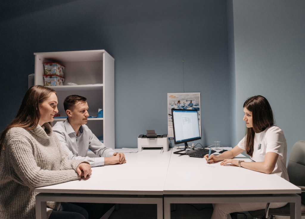 Casal conversando com uma médica em seu consultório para entender se vasectomia pode ser revertida