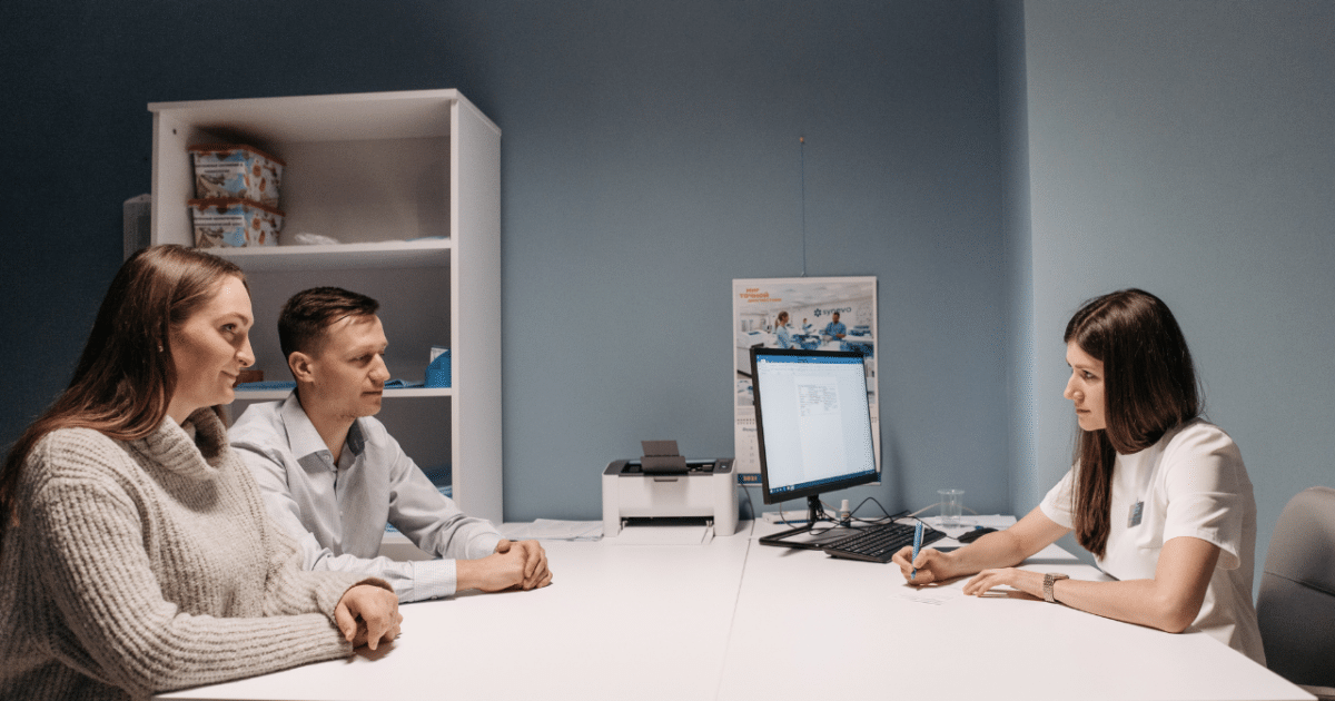 Casal conversando com uma médica em seu consultório para entender se vasectomia pode ser revertida