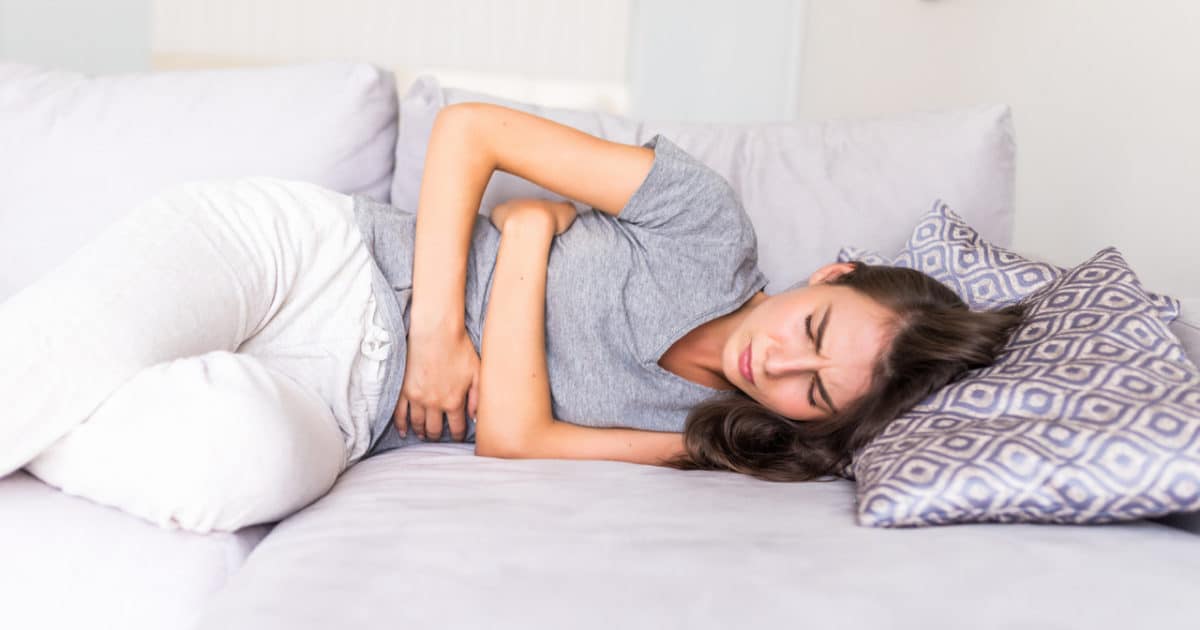 Imagem de uma mulher deitada com dor nos rins para simbolizar o que é feocromocitoma