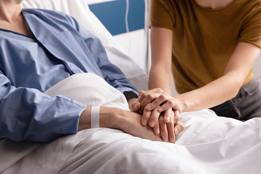 Imagem de uma mulher hospitalizada, de mãos dadas com outra mulher visitante para simbolizar o fungo Candida auris